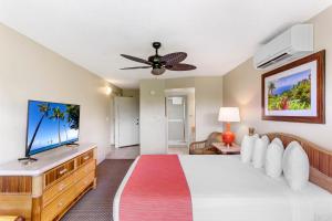 Maui Banyan Vacation Club في ويليا: غرفة نوم مع سرير وتلفزيون بشاشة مسطحة