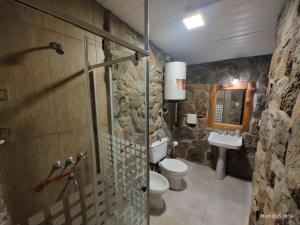 een stenen badkamer met een toilet en een wastafel bij Vado Biguá in Valle Hermoso