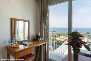 a room with a desk and a window with a view of the ocean at Siren Flower Hotel in Nha Trang