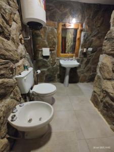 een stenen badkamer met een toilet en een wastafel bij Vado Biguá in Valle Hermoso