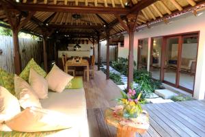 sala de estar al aire libre con sofá y mesa en Cili Emas Oceanside Resort, en Tejakula