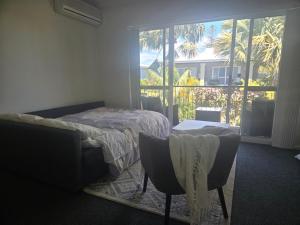 ein Schlafzimmer mit einem Bett und einem großen Fenster in der Unterkunft Waterfront Hideaway with Pool, Spa & BBQ Area jetty available in Mandurah + 35 Fotos