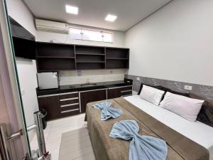 a small bedroom with a bed and a sink at Suítes Vivence Hotel in Goianésia