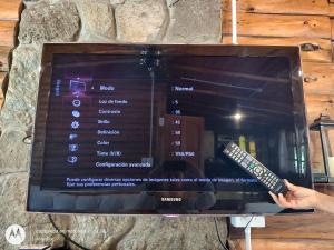 een persoon met een afstandsbediening voor een televisie bij Vado Biguá in Valle Hermoso