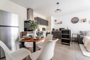 a kitchen and dining room with a table and chairs at Le Magnifique - Grand balcon - Netflix - Grand Marché in Saint-Priest