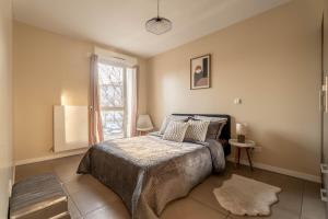 a bedroom with a bed and a window at Le Magnifique - Grand balcon - Netflix - Grand Marché in Saint-Priest