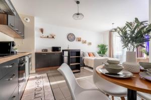 a kitchen and living room with a table and chairs at Le Magnifique - Grand balcon - Netflix - Grand Marché in Saint-Priest