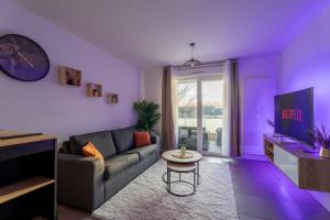 a purple living room with a couch and a table at Le Magnifique - Grand balcon - Netflix - Grand Marché in Saint-Priest