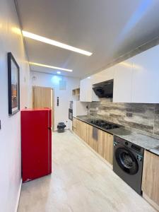 a kitchen with a red refrigerator in a room at 2-Bedroom Apartment with Pool, Gym, Tennis & Snooker in Lekki Ajah in Lekki
