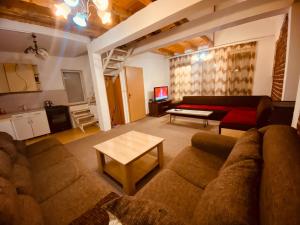 a living room with a couch and a table at Villat Bardhoshi in Mitrovicë