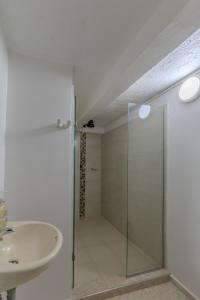 a bathroom with a glass shower and a sink at Hotel Stadio Cali in Cali