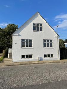 a white house sitting on the side of a street at Unique Living - Herning City Central House in Herning