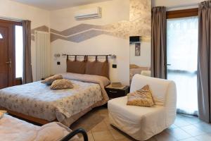 a bedroom with two beds and a chair at La Casa Del Grillo 1 in Aosta