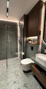 a bathroom with a shower and a toilet and a sink at Apartamenty MOOD HARMONY Garbary 40 in Poznań +22 photos