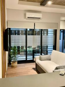 a living room with a couch and a large window at La Rosa Apartment in Adrogué +8 photos