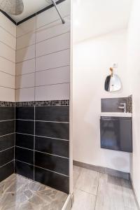 a bathroom with a shower with black and white tiles at L'Odyssée - Mercure - Gare - Wifi - Netflix in Tourcoing