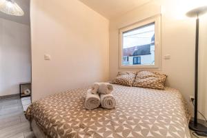 a bedroom with a bed with towels on it at L'Odyssée - Mercure - Gare - Wifi - Netflix in Tourcoing