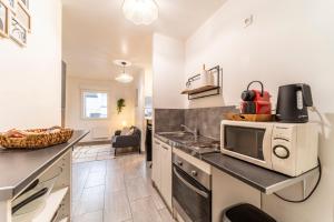 a kitchen with a counter top with a microwave at L'Odyssée - Mercure - Gare - Wifi - Netflix in Tourcoing +3 photos