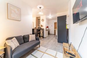 a living room with a couch and a kitchen at L'Odyssée - Mercure - Gare - Wifi - Netflix in Tourcoing