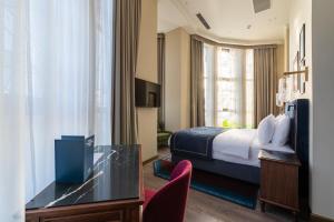 una habitación de hotel con una cama y un escritorio en Hotel Indigo Batumi - Old Town by IHG, en Batumi