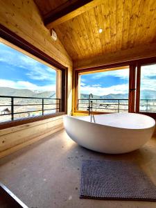 a large bath tub in a room with windows at Le refuge des cimes, vue Panoramique ! in Formiguères
