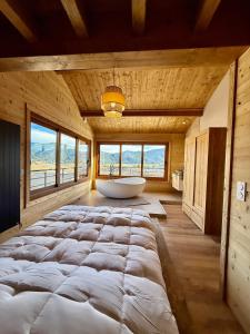 a large bedroom with a large bed and a tub at Le refuge des cimes, vue Panoramique ! in Formiguères