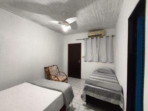 a bedroom with two beds and a ceiling fan at Pousada Adventure in Chapada dos Guimarães