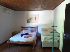 a small bedroom with a bed and a cross at Lorena'Haus in Bombinhas +12 photos