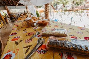 a table with a table cloth with food on it at Pousada Chalés Jardim das Aguas in Olímpia