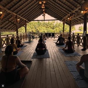 a group of people doing yoga in a pavilion at Costa Catalina in Santa Catalina