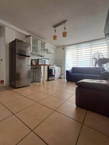 a living room with a refrigerator and a kitchen at Sector Norte 1 Dormitorio in Antofagasta