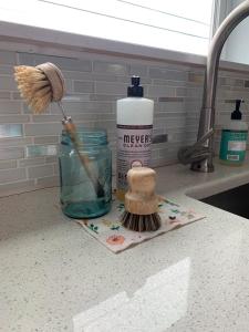 a brush and a jar of water on a kitchen counter at Hummingbird downtown water view apartment in Ketchikan