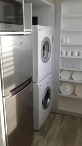 a kitchen with a refrigerator and a washer and dryer at Hummingbird downtown water view apartment in Ketchikan