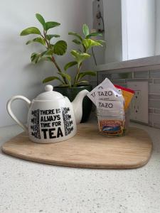 two coffee mugs sitting on a wooden cutting board at Hummingbird downtown water view apartment in Ketchikan