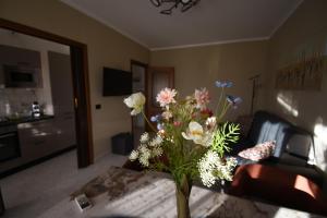 a vase of flowers on a table in a living room at A casa di Gina in Airasca