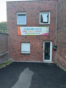 a brick building with a sign on the side of it at L'Odyssée - Mercure - Gare - Wifi - Netflix in Tourcoing