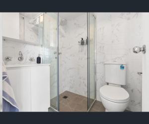 ein weißes Badezimmer mit Toilette und Dusche in der Unterkunft Bondi Beach Studio with an ocean view in Sydney