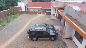 a black car parked on the side of a building at Palm Suites Unit3 in Mbale