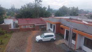 a white car parked in a parking lot between buildings at Palm Suites Unit3 in Mbale