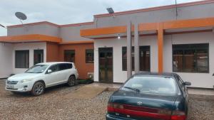 two cars parked in front of a building at Palm Suites Unit3 in Mbale