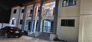 a black car parked in front of a building at Purple Springs Elmina #1 in Esamang