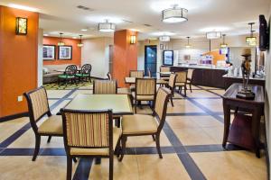 ein Restaurant mit Tischen und Stühlen und eine Bar in der Unterkunft Holiday Inn Express Peachtree Corners-Norcross by IHG in Norcross