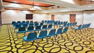 einen Konferenzraum mit blauen Stühlen und einem Podium in der Unterkunft Holiday Inn Express Peachtree Corners-Norcross by IHG in Norcross