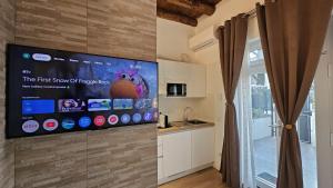 a kitchen with a tv on the wall at Junior Suite, Villa Joy Verona, Romantic, with garden, elegant living room, near the city center in Verona