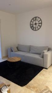 a living room with a couch and a clock on the wall at Le gîte du château in Saint-Père-sur-Loire