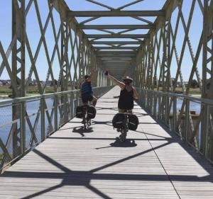 two people riding bikes on a bridge at Le gîte du château in Saint-Père-sur-Loire