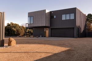 een groot zwart huis met een garage bij House Peron - Bayside Luxury in St Helens