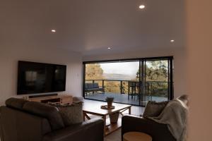 een woonkamer met 2 stoelen en een flatscreen-tv bij House Peron - Bayside Luxury in St Helens