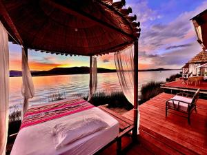 a bed on a deck with a view of the water at Titicaca Origins Perú in Puno