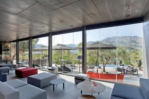 uma sala de estar com uma grande parede de vidro em VIVOOD Landscape Hotel & Spa - Designed for Adults em Benimantell